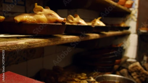 Spanish suckling pigs displayed on kitchen shelves. photo