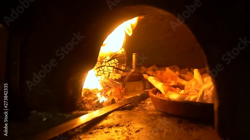 Spanish suckling pig being cooked in a wood fire oven.