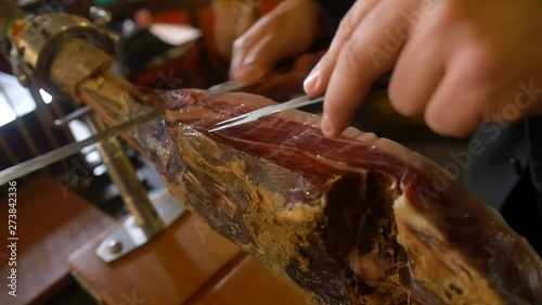 Traditional serrano ham being sliced and served in Spain.