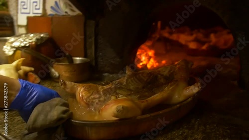 Spanish suckling pig being cooked in a wood fire oven. photo