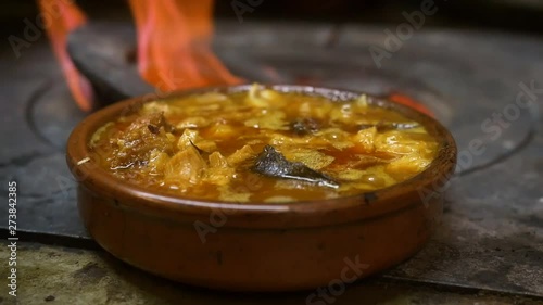 Hearty Spanish comfort food (beef tripe stew) cooked over coal stove. photo