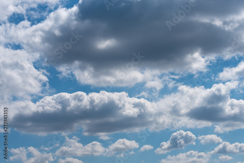 Thick gray clouds in the blue sky on a sunny day. Natural background.