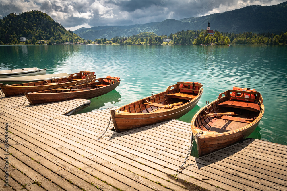 scenic view on beautiful wooden flat rowing boats on lake bled, slovenia, go green concept