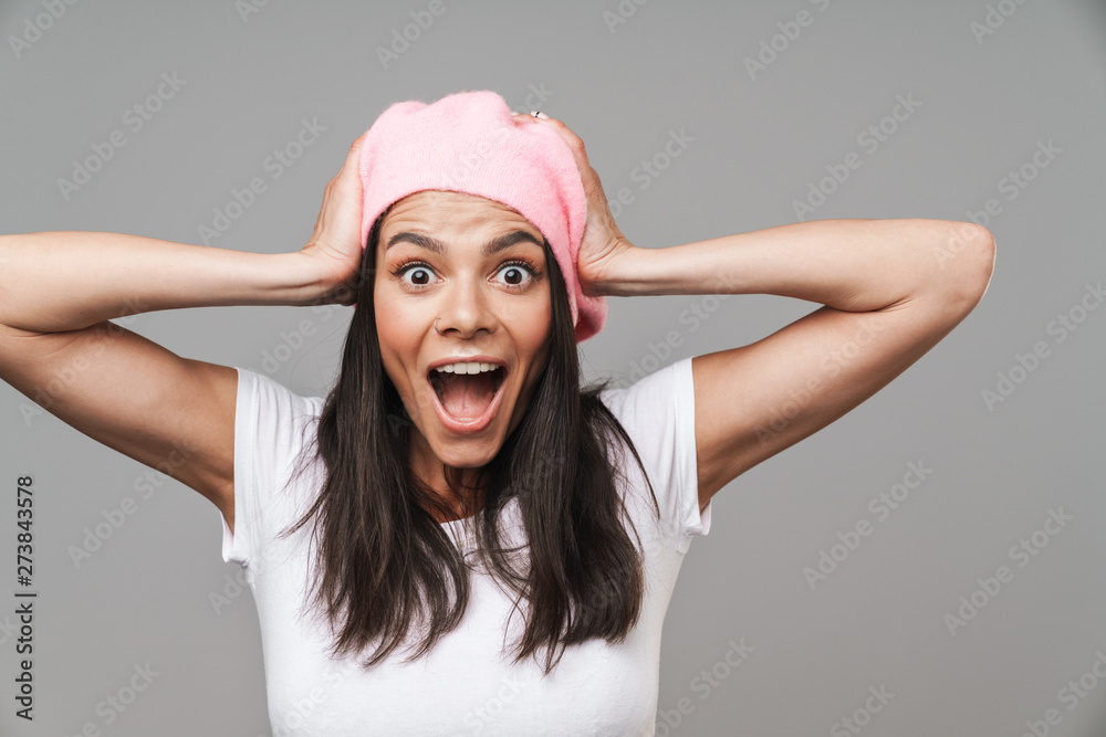 Photo closeup of emotional pretty woman in basic t-shirt and beret screaming while grabbing her head Photo closeup of emotional pretty woman in basic t-shirt and beret screaming while grabbing her head