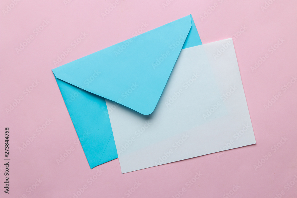 Blue envelope with a blank for text on a bright trendy pink background. top view Blue envelope with a blank for text on a bright trendy pink background. top view