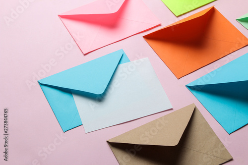 Multicolored envelope with blank for text on a bright trendy pink background. free space.