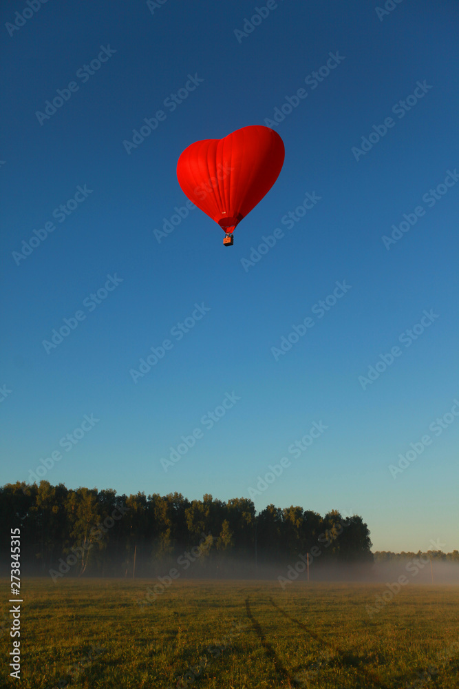 beautiful summer sunny nature landscape with a flying heart-shaped balloon in the blue sky beautiful summer sunny nature landscape with a flying heart-shaped balloon in the blue sky