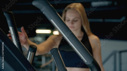 Young woman doing workout on orbitrek in gym