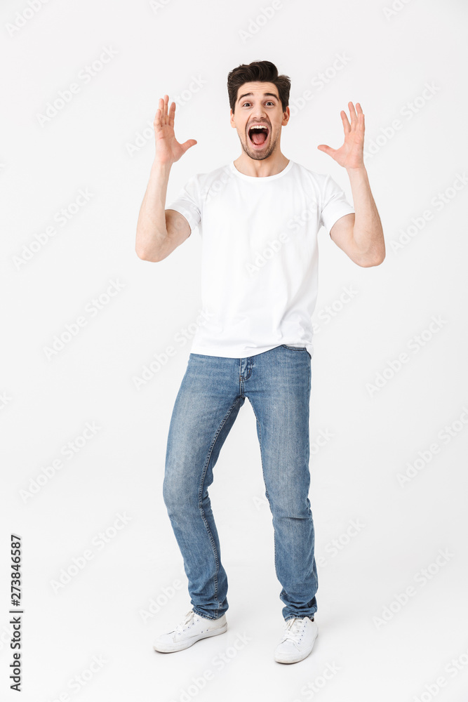 Excited happy young man posing isolated over white wall background. Excited happy young man posing isolated over white wall background.