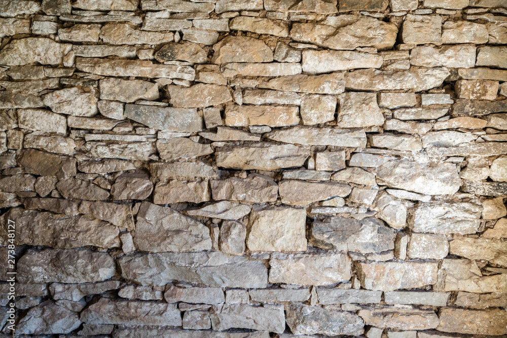 Close up of old flat brown and gray stone wall texture. Layered rocks on a house or building. Architectural stone wall exterior typical in Bulgaria Close up of old flat brown and gray stone wall texture. Layered rocks on a house or building. Architectural stone wall exterior typical in Bulgaria