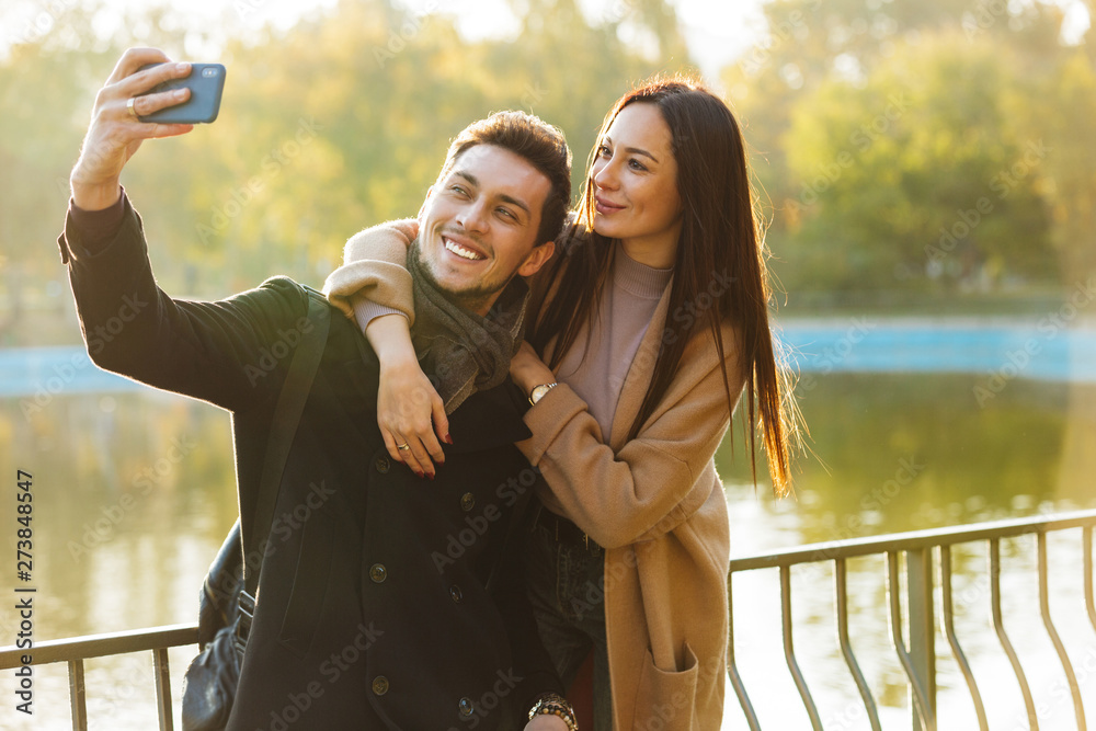 A couple who are university students posing for a self-portrait with a  smart phone with a small..., Stock Photo, Picture And Royalty Free Image.  Pic. DPI-12523118 | agefotostock