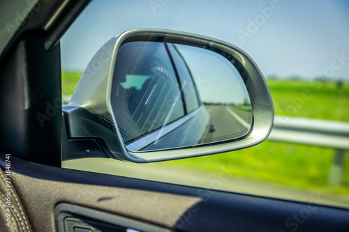 Rear view side mirror in car. Landscape in the sideview mirror of a car , on road countryside.