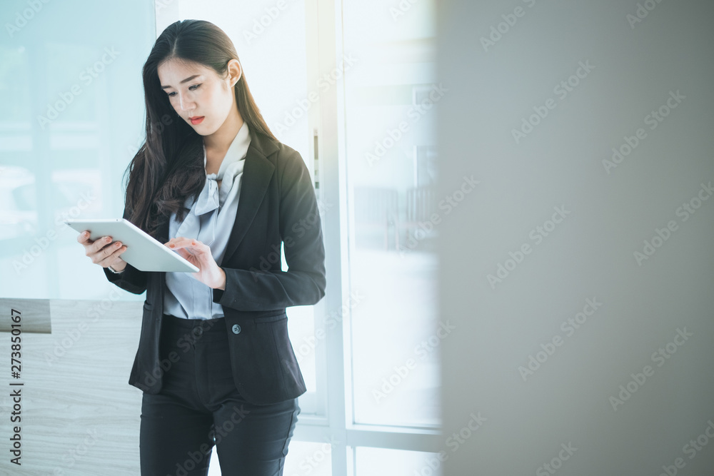 Beautiful businesswoman looking at tablet while she working in her workplace. Beautiful businesswoman looking at tablet while she working in her workplace.