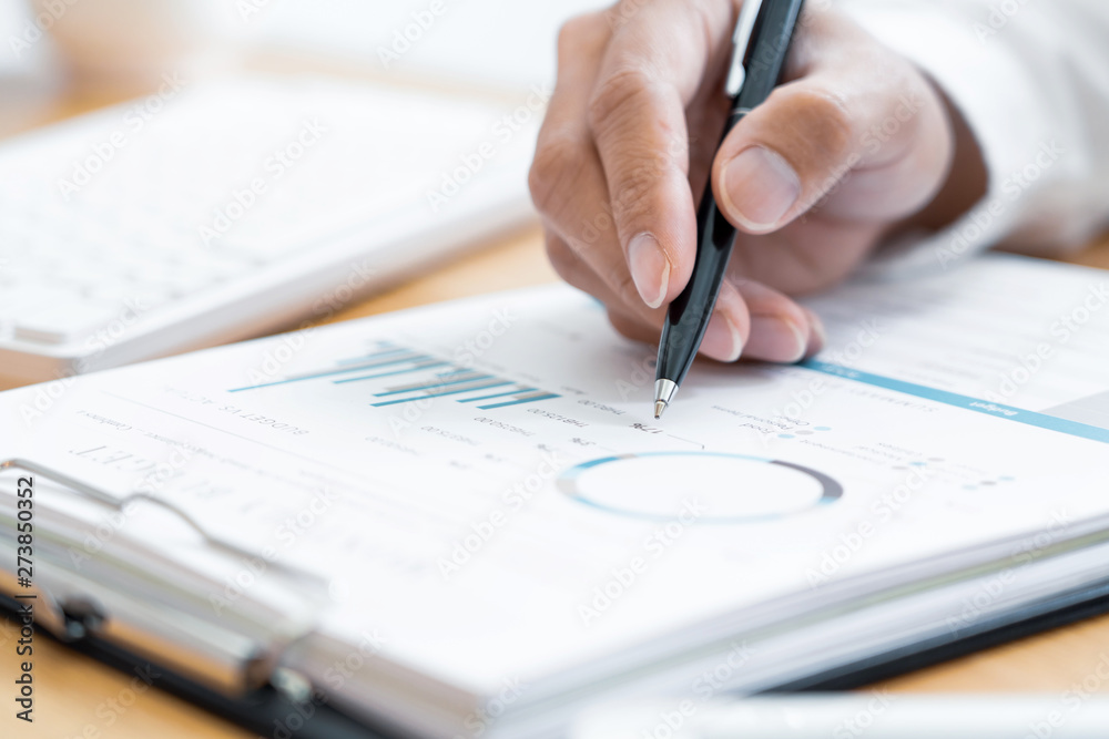 Close-up of hands Businessman reading and writing with pen signing contract over document for Completing Application Form at work in office. Close-up of hands Businessman reading and writing with pen signing contract over document for Completing Application Form at work in office.