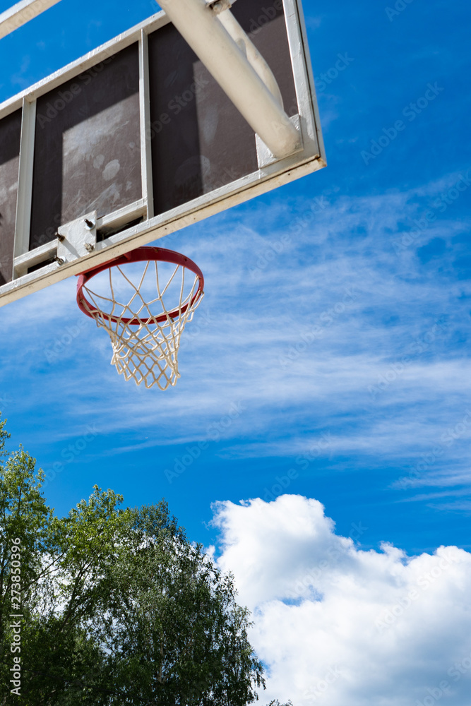 Basketball backboard with a ring on the street and blue sky Basketball backboard with a ring on the street and blue sky