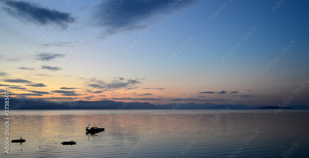 Seascape, lonely yacht. Setting sun in the clouds Seascape, lonely yacht. Setting sun in the clouds