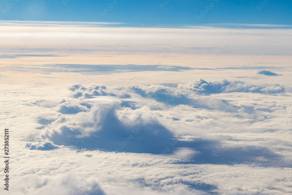 Beautiful white clouds in blue sky. View from airplane