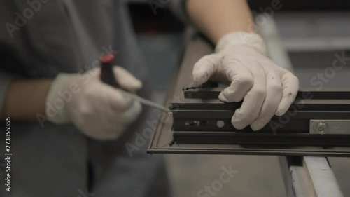 Worker screwing a window, drill macro, processing of aluminum parts in a Production of aluminium Windows Workshop. Manufacturing of plastic double-glazed windows. Factory for PVC windows and doors.