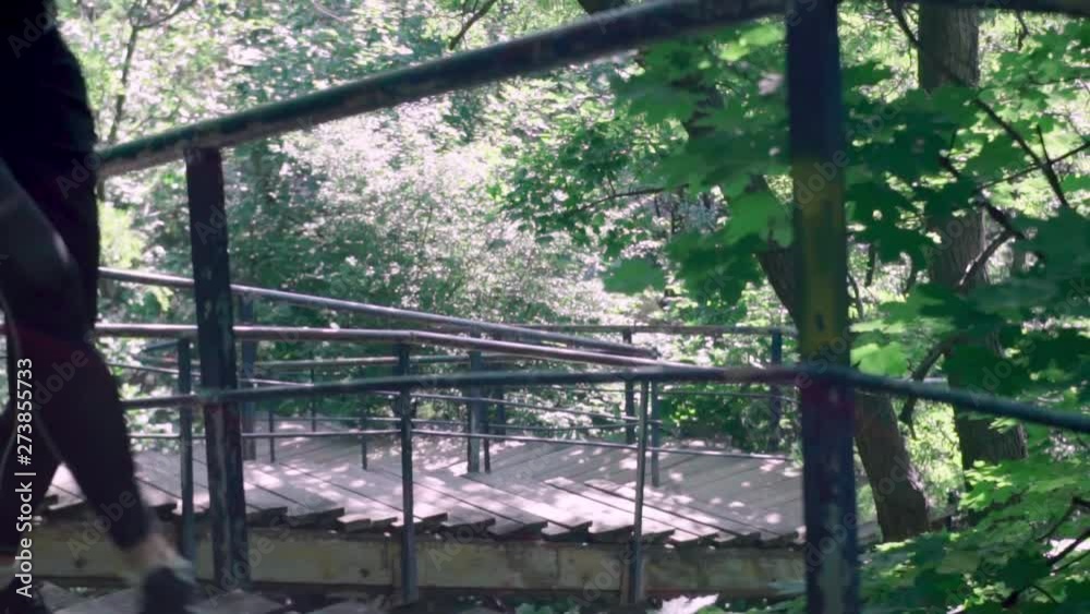 Young male runner training on the wooden stairs in the spring park Young male runner training on the wooden stairs in the spring park