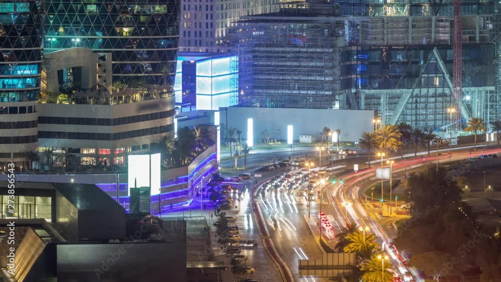 Skyline view of intersection traffic on Al Saada street near DIFC night timelapse in Dubai, UAE. Illuminated skyscrapers in financial centre aerial view from above in downtown Skyline view of intersection traffic on Al Saada street near DIFC night timelapse in Dubai, UAE. Illuminated skyscrapers in financial centre aerial view from above in downtown