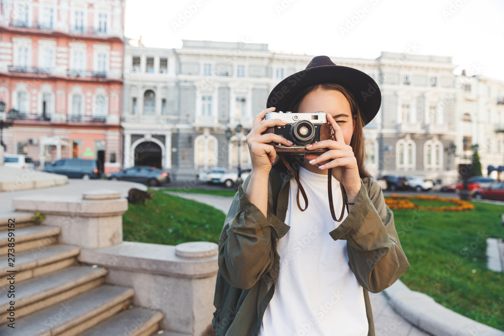 Beautiful woman photographer tourist walking outdoors in beautiful spring day holding camera.