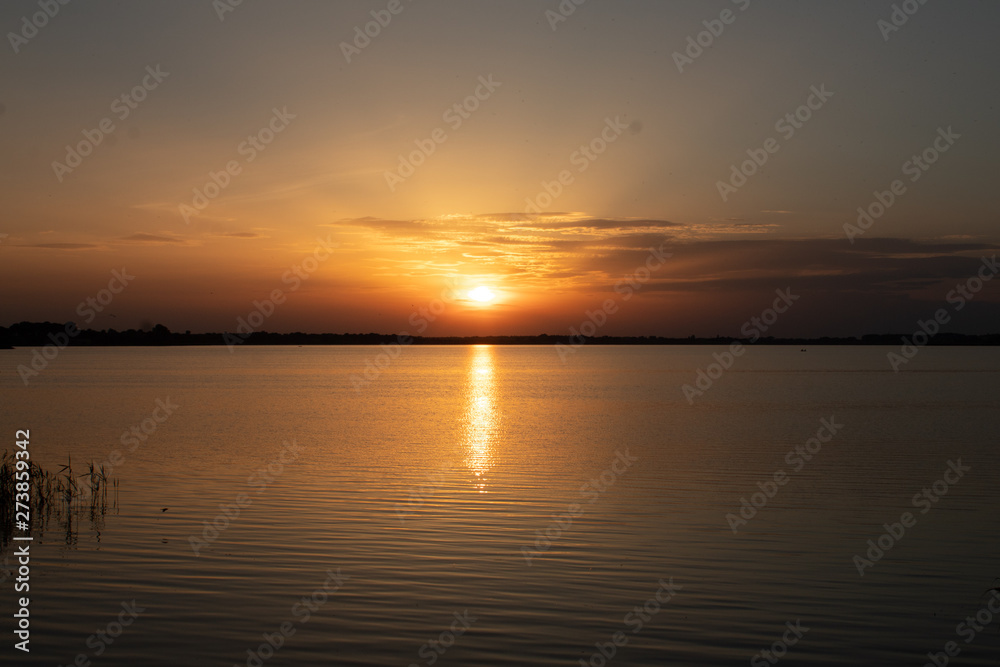 Sunset on the lake, reflection in the water, sun path,