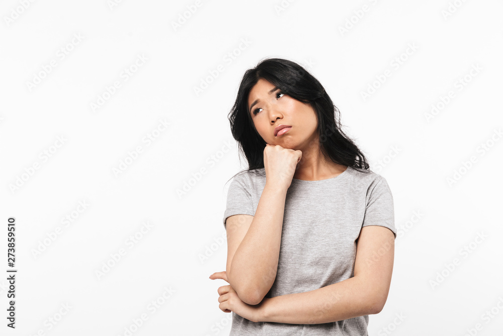 Asian thinking beautiful young woman posing isolated over white wall background. Asian thinking beautiful young woman posing isolated over white wall background.