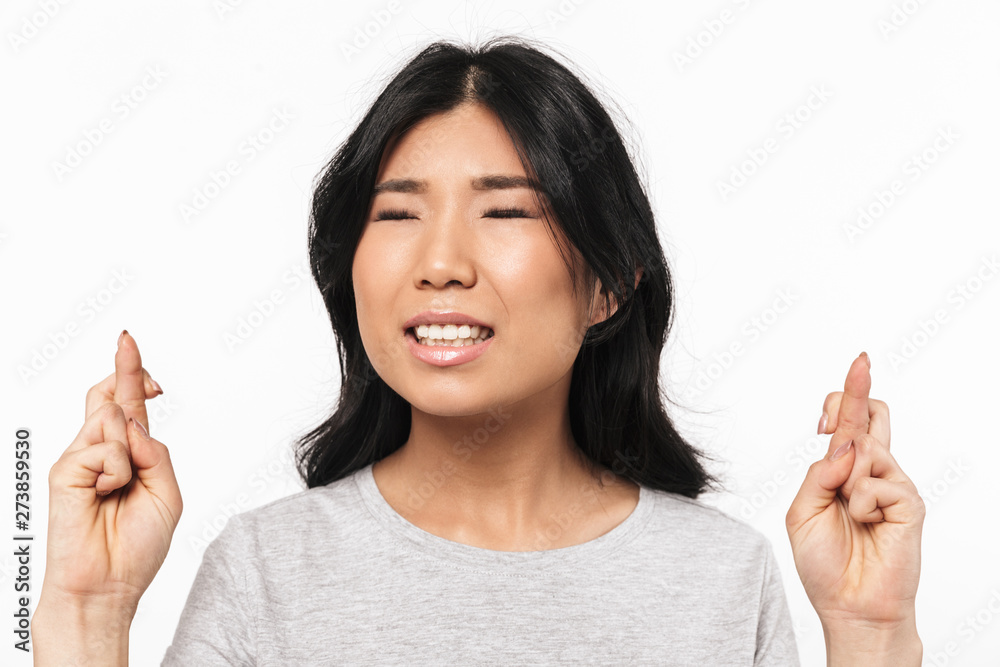 Nervous beautiful young woman posing isolated over white wall background make hopeful gesture. Nervous beautiful young woman posing isolated over white wall background make hopeful gesture.