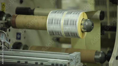 Multi Label Printing Rolls with High speed labeling machine in industrial factory, sticker on product in manufacture. Flexible packaging. Close-Up Macro.