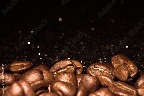 Roasted coffee beans. Seeds of freshly roasted coffee with smoke. Coffee beans closeup with emphasis on the grain with smoke. © ninell