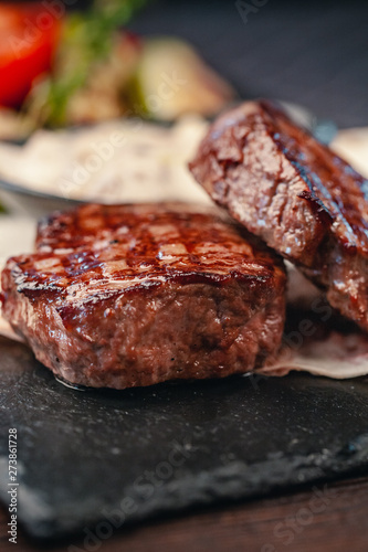 grilled beef steak with vegetables on gray slate background