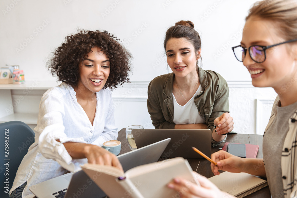Group of cheerful young women studying together Group of cheerful young women studying together