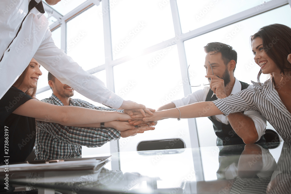 business team showing their unity by putting their hands together business team showing their unity by putting their hands together