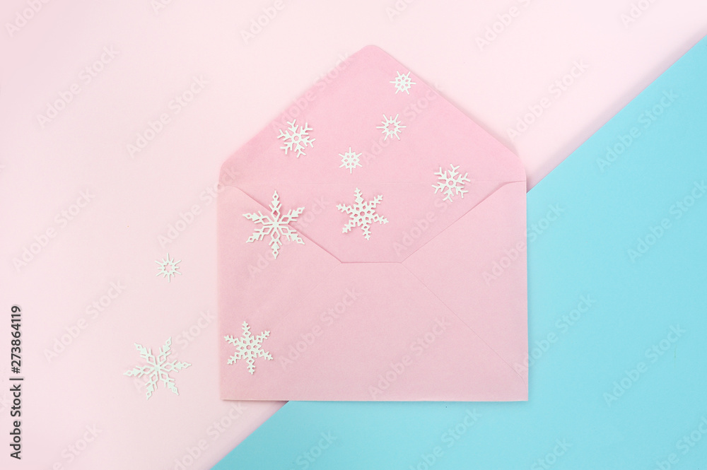 Open pink envelope with snowflake on pink and blue background. Top view, Christmas concetp style