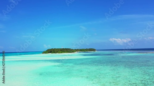 dolly out shot of distant desert island in caribbean sea photo