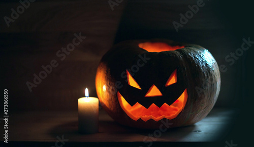 candle and creepy smiling pumpkin for Halloween