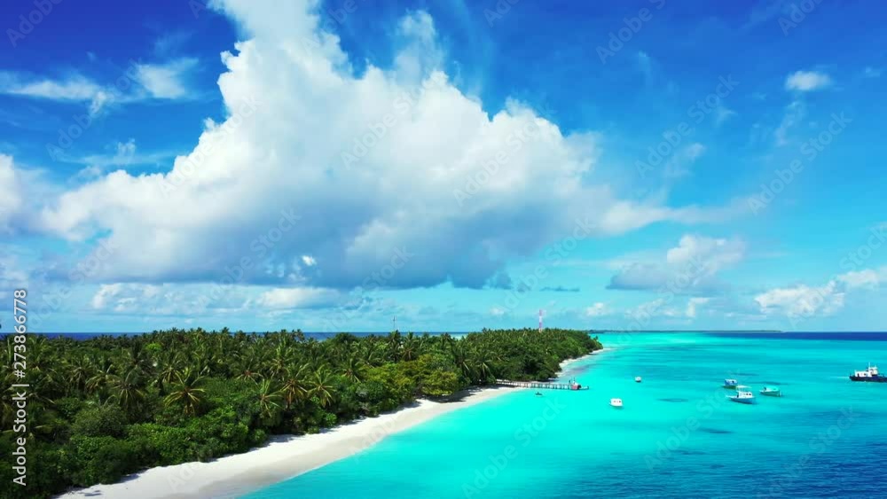 aerial drone parallax shot of tropical uninhabited island with cocos palms surrounded by crystal clear ocean water aerial drone parallax shot of tropical uninhabited island with cocos palms surrounded by crystal clear ocean water
