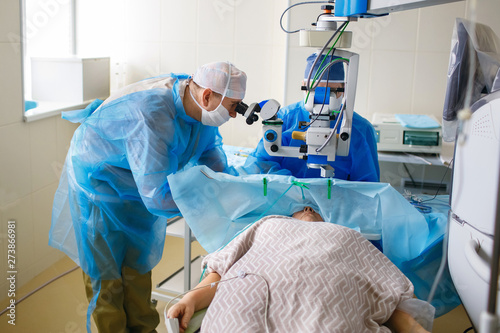 Two ophthalmologist perform an operation in the operating room, delicate work with the eyes, eye surgery, two scientists look through microscopes