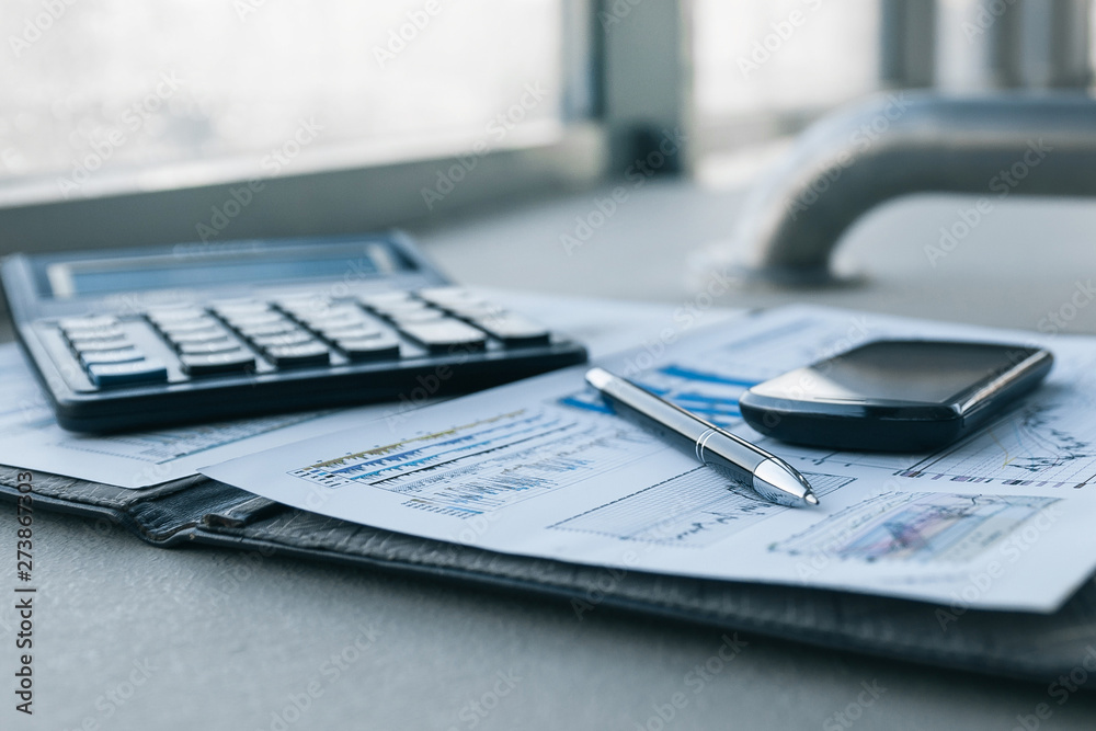 mobile phone and financial documents on the desktop. mobile phone and financial documents on the desktop.
