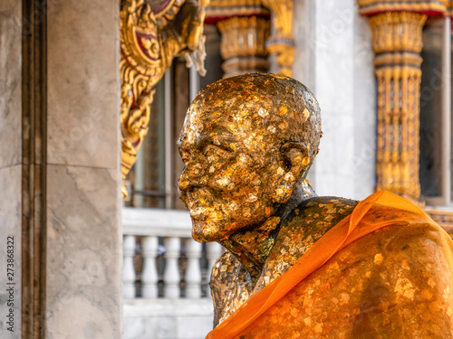 Statue de moine bouddhiste avec feuilles d'or photo