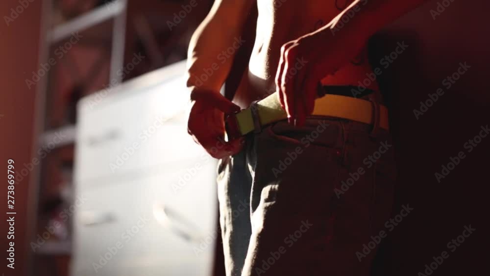 Young pretty sexy woman in underwear pulls on blue jeans and tightens the belt. slender athletic woman with tattoo dressed in the room in front of the mirror. Full HD stock footage