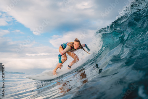 Beautiful surfer girl on surfboard. Woman in ocean during surfing. Surfer and barrel wave