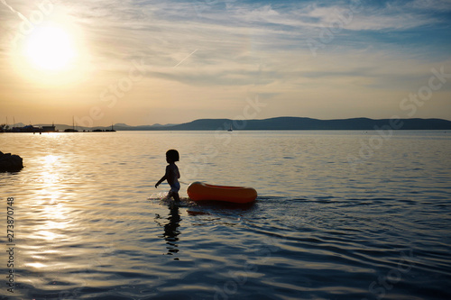 Cute small boy playing with an inflatable boat in Lake Balaton, Hungary © andras_csontos