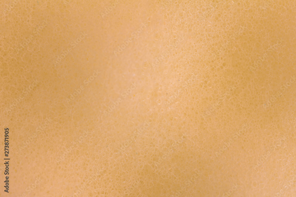 Abstract beige background with shadows creating volume. Super macro image of the beige surface of a sponge porous material. Enlarged photo of a beige sponge for washing dishes with small holes, pores. Abstract beige background with shadows creating volume. Super macro image of the beige surface of a sponge porous material. Enlarged photo of a beige sponge for washing dishes with small holes, pores.