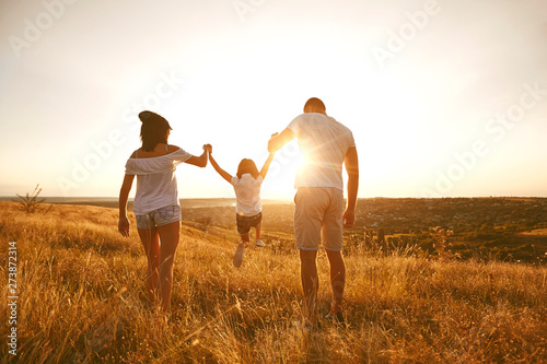 Happy family on nature in summer at sunset.