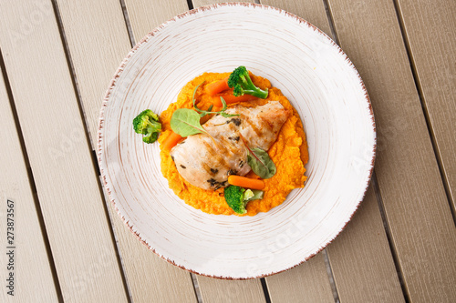 Obraz na płótnie Chicken breast steak with carrot puree baby carrot and broccoli. Grilled chicken slice with baby carrot puree. wooden backgrounf w salonie