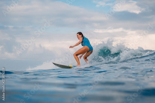 Surf girl on surfboard. Woman in ocean during surfing. Surfer and wave