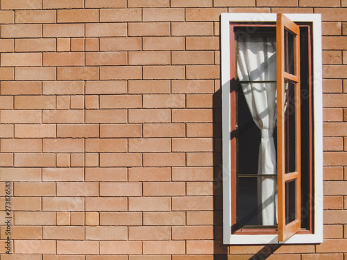 wood window open on brown brick wall