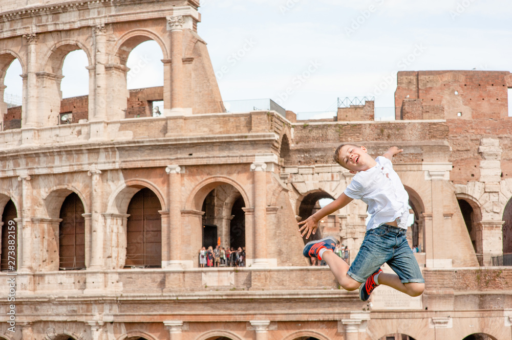 Happy boy jumps at the coliseum in rome, Italy. Travel concept. Space for text