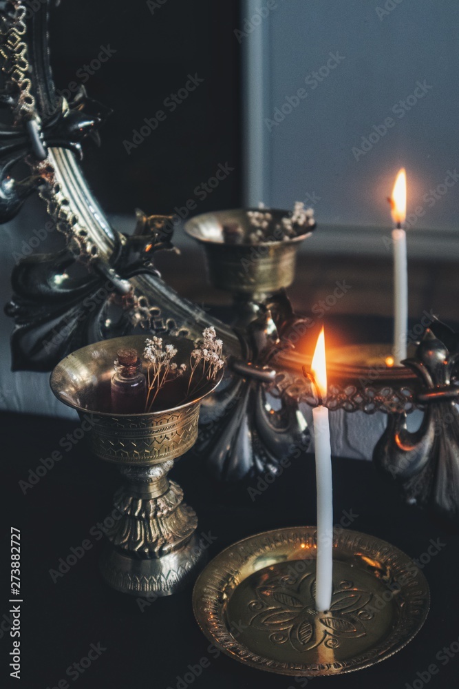 Mirror magick witchcraft - scrying with a white lit burning candle to read  the flame. A reflection
